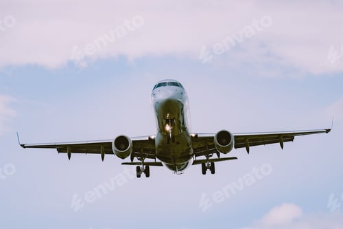 Preview: Low angle shot of an airplane flying in a cloudy sky