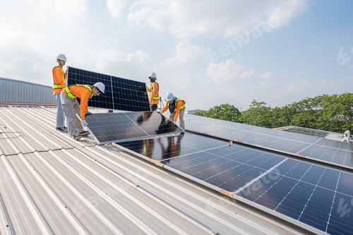 Preview: Men technicians carrying photovoltaic solar moduls on roof of factory.
