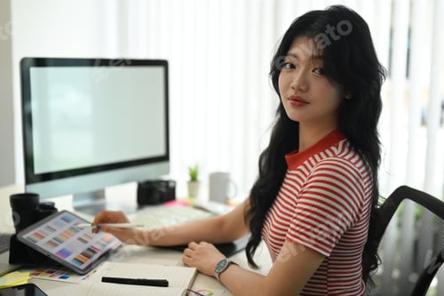 Preview: Creative woman using digital tablet and working on desk at graphic studio