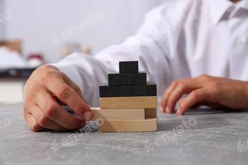 Preview: A toy wooden house in the hands of a man
