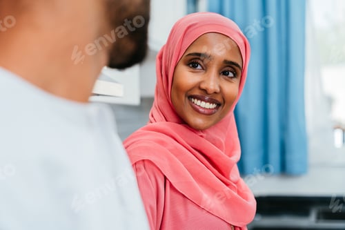 Preview: Happy middle eastern couple wearing traditional arab clothing at home