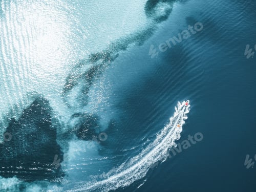 Preview: Aerial top shot of a boat leaving trail on clear seawater