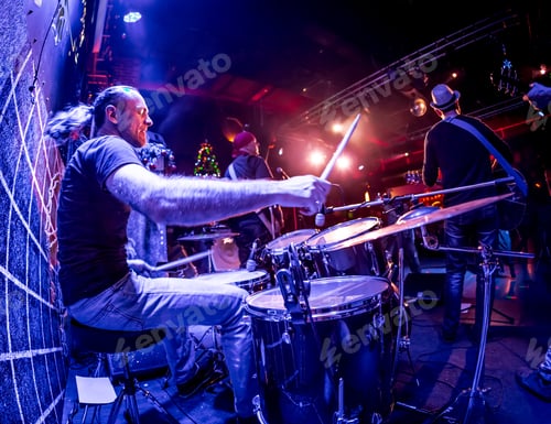 Preview: Drummer playing on drum set on stage.