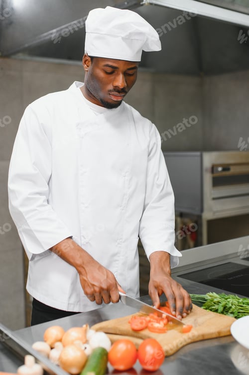 Preview: Portrait of happy African American male chef standing in restaurant kitchen