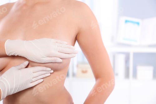Preview: Doctor checking woman's breast at hospital, closeup