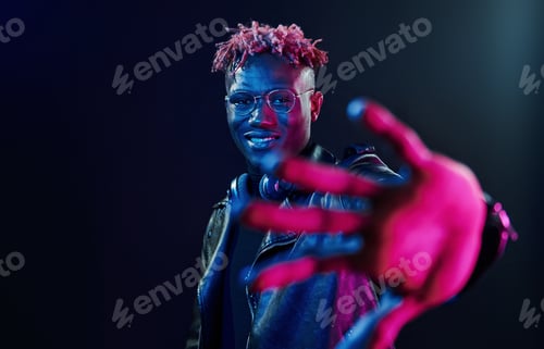 Preview: Futuristic neon lighting. Young african american man in the studio