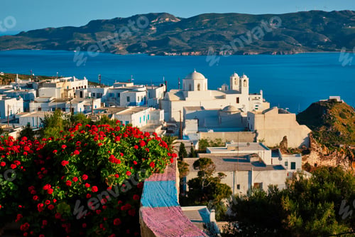 Preview: Picturesque scenic view of Greek town Plaka on Milos island over red geranium flowers