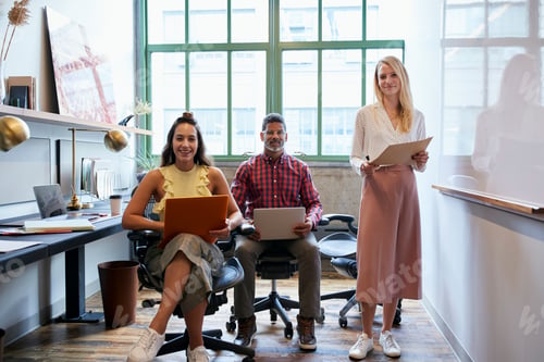 Preview: Three coworkers in a team meeting looking to camera