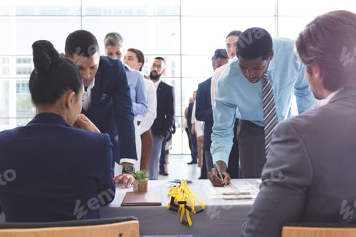 Preview: Front view of diverse business people checking in at conference registration table in office lobby