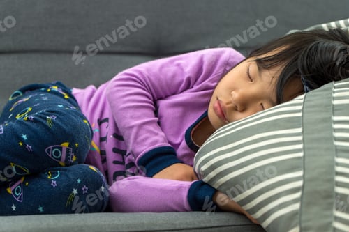 Preview: Little Asian child taking nap on couch