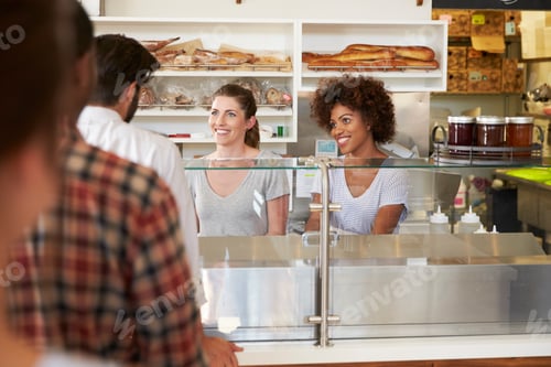 Preview: A queue of customers served by two women at a sandwich bar