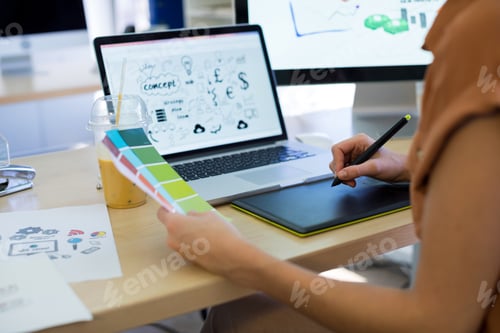 Preview: Female executive working over graphic tablet at her desk