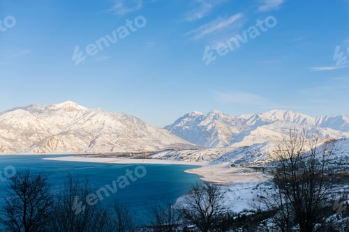Preview: Charvak reservoir with blue water on a clear winter day in Uzbekistan