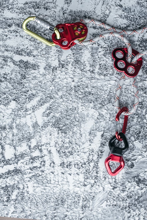 Preview: Isolated photo of climbing equipment. Part of carabiner lying on the white and grey colored table