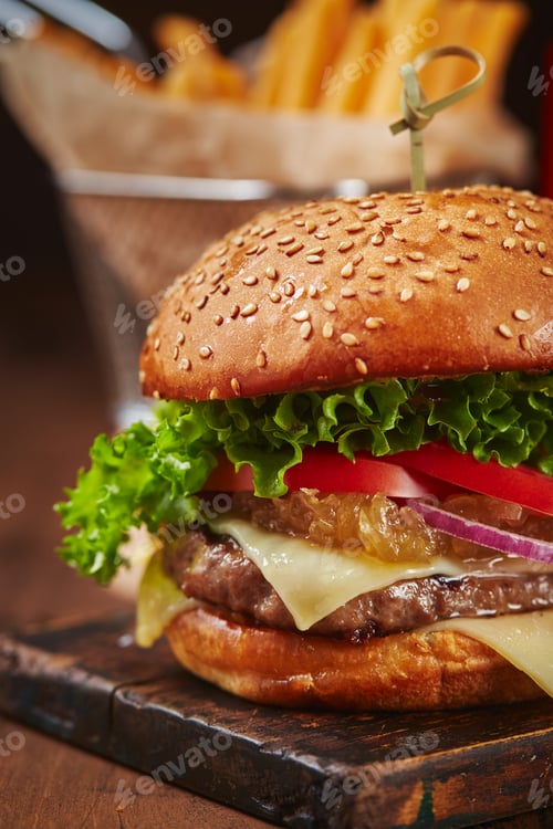 Preview: Appetizing homemade burger with beef, cheese and onion marmalade close-up. Fast food concept