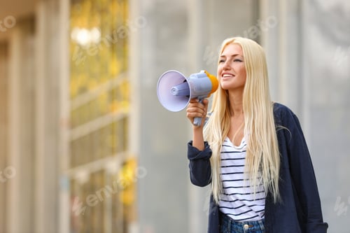 Preview: Emotional young woman with megaphone outdoors. Protest leader