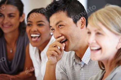 Preview: Sharing the joke. Shot of an Asian man laughing at a table with his coworkers out of focus.