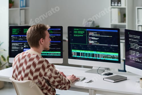 Preview: Young Man Working with Code on Multiple Computer Monitors