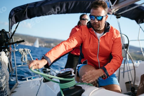 Preview: Handsome strong man sailing with his friends