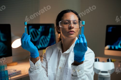 Preview: Female scientist examining test tubes creating medicine