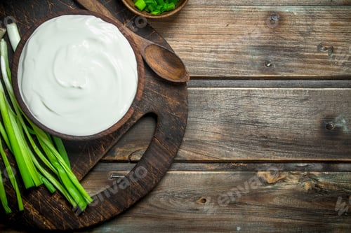 Preview: Fresh sour cream in bowl with green onions .
