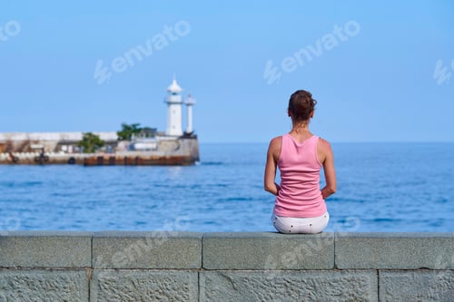 Preview: A young woman looks into the distance at the lighthouse
