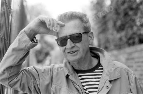 Preview: Senior man wearing sunglasses and adjusting his hair in monochrome analog film style