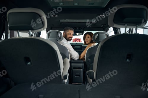 Preview: Man and woman sitting at new car