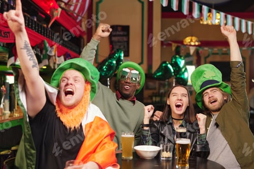 Preview: Group of young excited football fans expressing triumph during football game