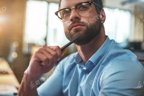 Preview: Lost in thougths. Portrait of young bearded man in eyeglasses and formal wear looking away and