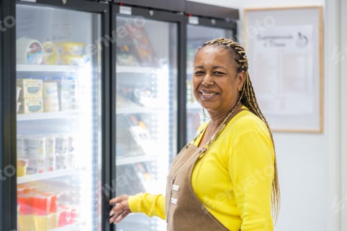 Preview: Middle-aged market clerk next to the fridges
