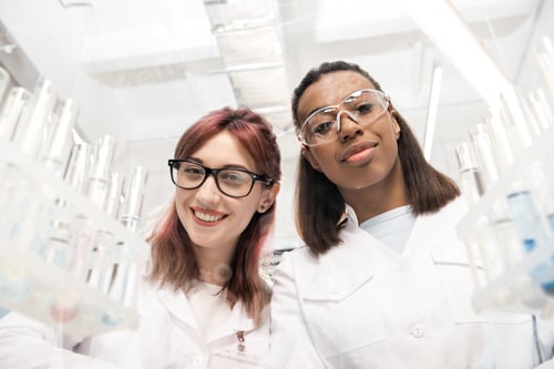 Preview: low angle view of scientists group in white coats in laboratory