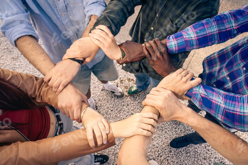 Preview: Diverse group of people linking arms together in a circle to show unity and teamwork.