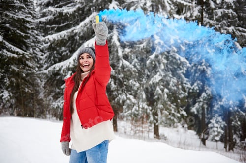 Preview: Young woman with smoke flare in snow