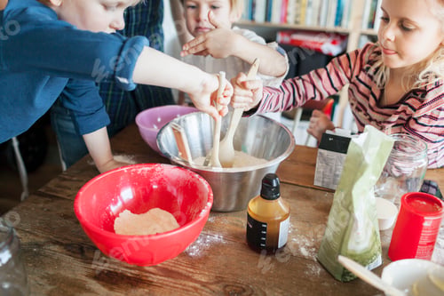 Preview: Siblings mixing ingredients while baking at home