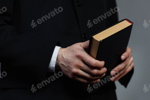 Preview: Pastor in suit holding Bible book