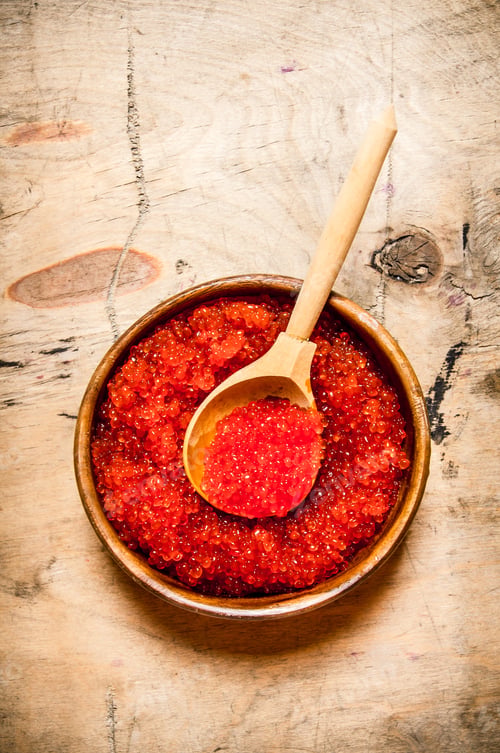 Preview: Red caviar in a wooden cup with a spoon.
