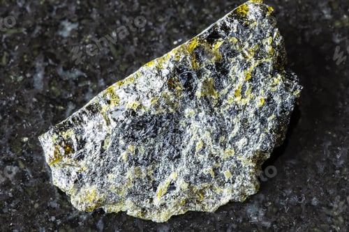 Vista previa: sample of raw diopside rock on black granite