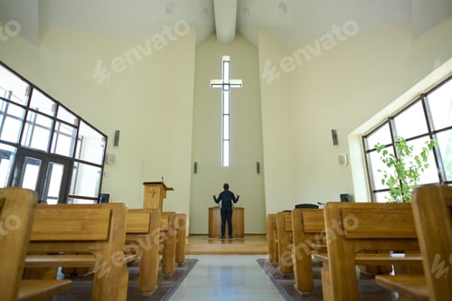 Preview: Interior of church with long aisle leading to pastor standing in front of cross