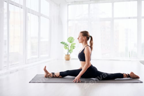 Preview: young beautiful woman doing yoga in a modern bright room with large windows. Yoga at home concept.