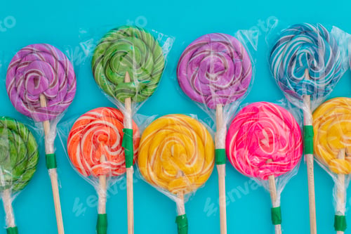 Preview: Candy in the form of colorful lollipops on a blue background.