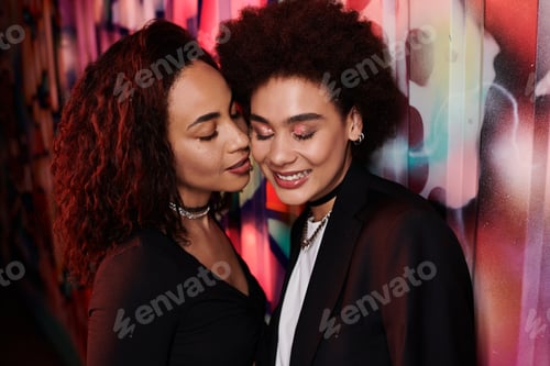 Preview: Two friends sharing a joyful moment against a vibrant graffiti backdrop in a lively urban setting