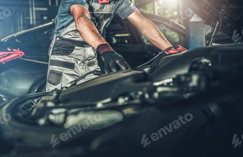 Preview: Car Mechanic Looking Under Vehicle Hood