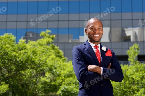 Preview: handsome african businessman smiling by building in city