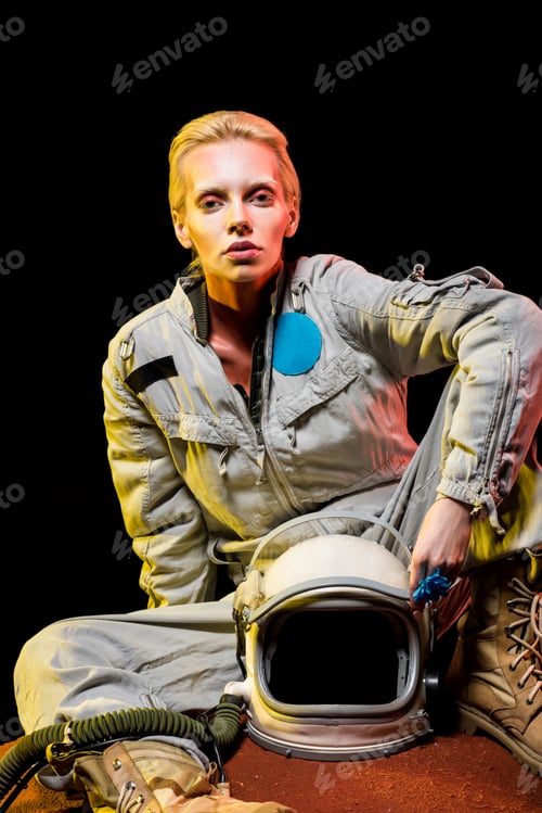 Preview: attractive astronaut in spacesuit with helmet sitting on planet