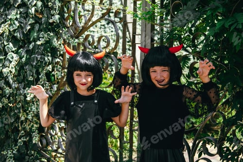 Preview: Sisters wearing wigs with red horns Halloween celebration party portrait.
