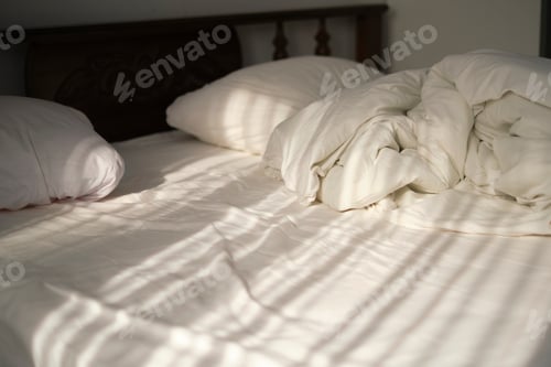 Preview: On a bed in a light bedroom the rays of the sun fall. reflection of curtains moving