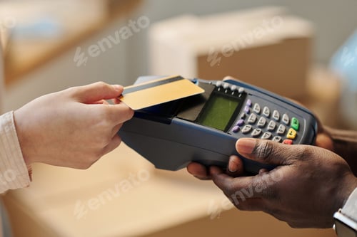 Preview: Woman using credit card to pay for service