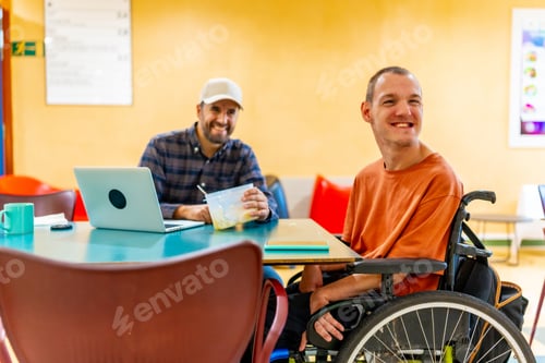Preview: Disabled man and coworker eating together in the dinning room