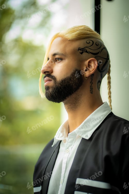 Preview: Mature male wearing a white shirt, with a neatly trimmed beard, is standing in front of a window